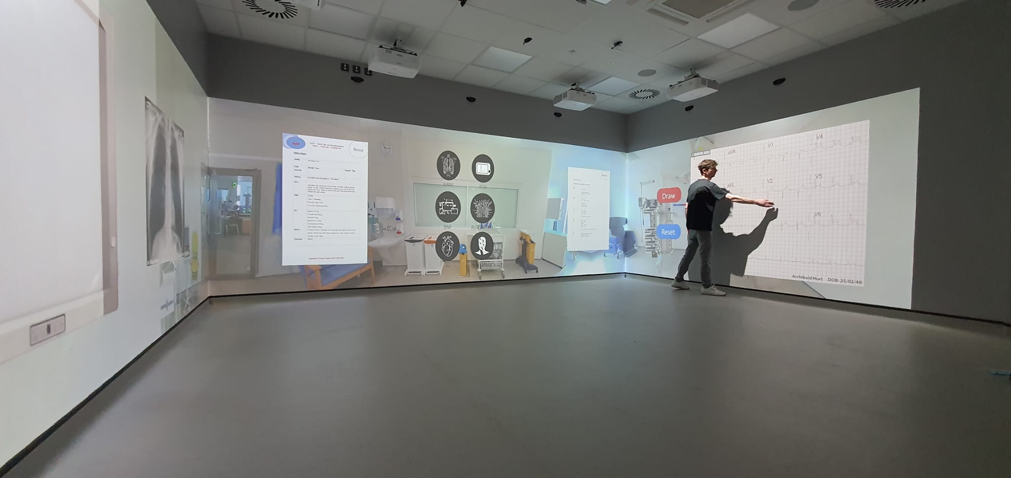 Node XR scenario projected on an immersive corner-projection wall, clinical training simulation
